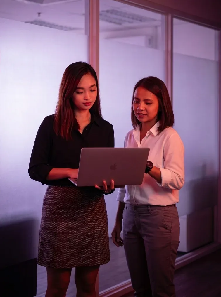 Two KDCI team members reviewing work together on a laptop